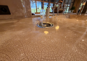 Custom-made countertop and sink with a terracotta-colored raku finish in a kitchen at a priory in the Combrailles region, crafted by Tradition Pierre